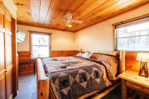 ein Schlafzimmer mit einem Bett und einer Holzdecke in der Unterkunft Mountain Chalet, Only 3 min to Sunday River ski lifts! in Bethel