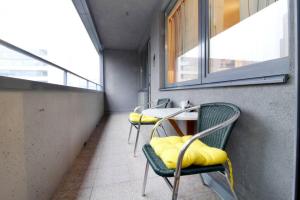 a room with three chairs and a table with yellow cushions at Grosse Balkonwohnung bei UNO City in Vienna