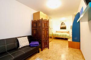 uma sala de estar com um sofá e um quarto em Grosse Balkonwohnung bei UNO City em Viena