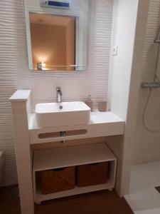 uma casa de banho com um lavatório branco e um espelho. em Cerveira House em Vila Nova de Cerveira
