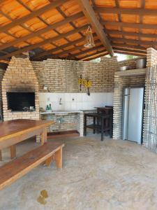 a kitchen with wooden tables and a stone wall at Quinta Zabelê in Barra Grande