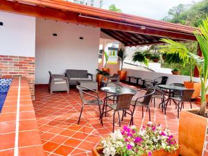 an outdoor patio with tables and chairs and flowers at Hotel Santorini in San Gil