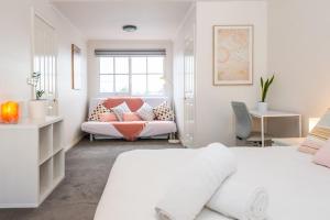 a white bedroom with a bed and a window at Brunswick 3bdrm townhouse, with parking by Custom Bnb Hosting in Melbourne