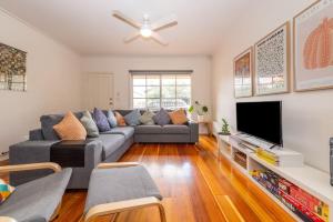 a living room with a couch and a tv at Brunswick 3bdrm townhouse, with parking by Custom Bnb Hosting in Melbourne