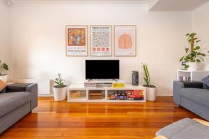 a living room with a television on a table at Brunswick 3bdrm townhouse, with parking by Custom Bnb Hosting in Melbourne
