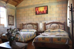 a bedroom with two beds and a brick wall at Casa Rural Santa Maria Regla in Huasca de Ocampo