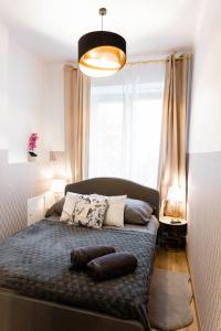 a bedroom with a bed with pillows and a large window at ClickTheFlat Royal Route Warecka Apart Rooms in Warsaw
