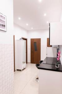 a white room with a counter and a refrigerator at ClickTheFlat Royal Route Warecka Apart Rooms in Warsaw