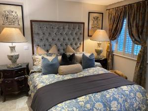 a bedroom with a large bed with blue pillows at Executive Corporate Penthouse in Woking