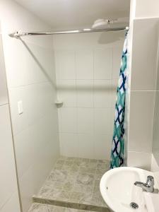a bathroom with a sink and a shower curtain at Hotel Santorini in San Gil