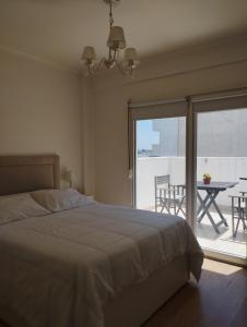 1 dormitorio con 1 cama y balcón con mesa en SEMIPISO CON TERRAZA PLAZA MITRE en Mar del Plata