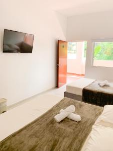 a bedroom with two beds and a flat screen tv at Hotel Santorini in San Gil