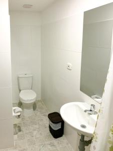 a white bathroom with a toilet and a sink at Hotel Santorini in San Gil