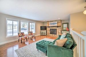 a living room with a green couch and a fireplace at Pocatello Retreat about 3 Mi to Downtown! in Pocatello