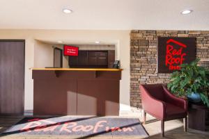 eine Lobby mit einem roten Schild und einem Stuhl in der Unterkunft Red Roof Inn Greensburg in Greensburg