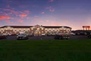 een groot gebouw met auto's geparkeerd op een parkeerplaats bij Red Roof Inn Greensburg in Greensburg