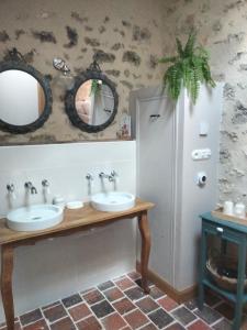 a bathroom with two sinks and a mirror at Les Chambres de Moulière 