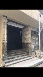 een gebouw met een zwarte deur en een trap bij الهرم شارع الزعفران من احمد ماهر خلف محافظة الجيزة in Caïro