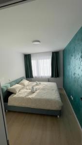 een slaapkamer met een bed met een blauwe muur bij Apartman Lux in Žepče