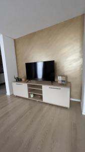 een woonkamer met een flatscreen-tv op een entertainmentcentrum bij Apartman Lux in Žepče