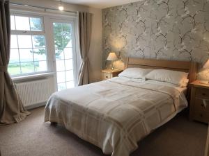 ein Schlafzimmer mit einem großen Bett und einem Fenster in der Unterkunft BRAUNTON WHITE HOUSE 4 Bedrooms in Braunton