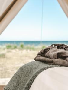 a blanket sitting on top of a bed near the beach at Surflogiet Gotland in Tofta