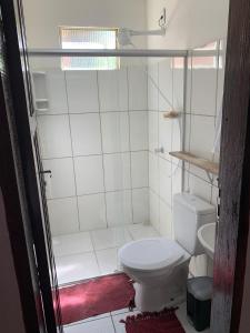 Baño blanco con aseo y lavamanos en Casa da Lua no centro da Vila de Caraíva ao lado da Igreja de Caraíva, en Caraíva