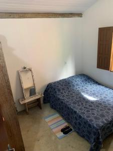 a bedroom with a bed and a mirror on the floor at Casa da Lua no centro da Vila de Caraíva ao lado da Igreja de Caraíva in Caraíva