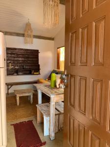 uma porta que leva a uma cozinha com uma mesa e um quarto em Casa da Lua no centro da Vila de Caraíva ao lado da Igreja de Caraíva em Caraíva