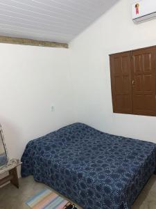 a bedroom with a blue bed and a cabinet at Casa da Lua no centro da Vila de Caraíva ao lado da Igreja de Caraíva in Caraíva