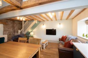 ein Wohnzimmer mit Sofa und Tisch in der Unterkunft Nadin Cottage in Buxton