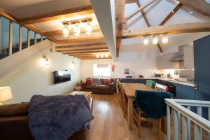 eine Küche und ein Wohnzimmer mit einem Tisch und einer Couch in der Unterkunft Nadin Cottage in Buxton