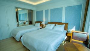 a hotel room with two beds and a table at Fontana Beach Hotel in Mokpo