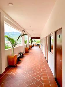 a corridor of a building with a hallway with plants at Hotel Santorini in San Gil