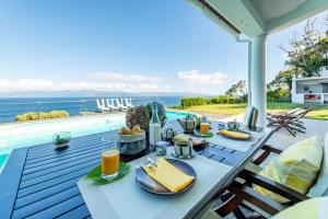 a table with food on it on a patio with a view of the ocean at A Casa do Jaime in Prainha de Baixo