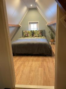 a bedroom with a bed in a attic at De Heerlykheid Wemeldinge, vlak bij strand en bos, ruime vakantiewoning met eigen patio in de karakteristieke Dorpsstraat in Wemeldinge