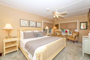 a bedroom with a large bed and a ceiling fan at The Hibiscus House of Fort Myers in Fort Myers