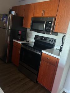 a kitchen with a black stove and a microwave at 1Bedroom Chic apartment in Phoenix