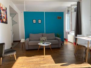 Una sala de estar con un sofá y una pared azul. en 1bispoitiers, en Poitiers