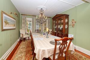 a dining room with a table and chairs and a chandelier at The Hibiscus House of Fort Myers in Fort Myers