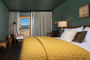 a bedroom with a large bed and a balcony at Hotel Marina Riviera in Big Bear Lake