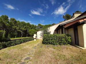 un patio junto a un edificio con un seto en Maison Seignosse, 2 pièces, 4 personnes - FR-1-239-425 en Seignosse