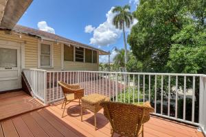 eine Veranda mit 2 Stühlen und einem Tisch auf einer Terrasse in der Unterkunft The Hibiscus House of Fort Myers in Fort Myers