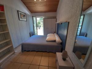 a small bedroom with a bed and a mirror at Maison Seignosse, 2 pièces, 4 personnes - FR-1-239-425 in Seignosse