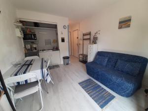 sala de estar con sofá azul y mesa en Appartement Seignosse, 1 pièce, 2 personnes - FR-1-239-437, en Seignosse