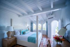 1 dormitorio con 1 cama y 1 mesa con lámpara en Windjammer Landing Villa Beach Resort, en Gros Islet