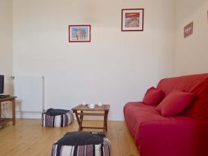 uma sala de estar com um sofá vermelho e uma mesa em Maison Les Sables-d'Olonne, 3 pièces, 4 personnes - FR-1-92-671 em Les Sables-dʼOlonne