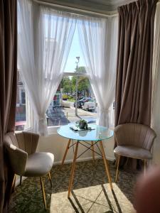 Seaside ground floor flat WIFI & FREE parking في سكرابورو: طاولة وكرسيين في غرفة مع نافذة