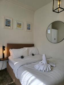 Seaside ground floor flat WIFI & FREE parking في سكرابورو: غرفة نوم بسريرين بيض مع مرآة