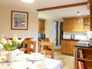 a kitchen with a table with a vase of flowers on it at Posbury Lodge in Crediton